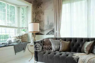 Elegant living room with plush sofa and large windows, perfect for relaxation.