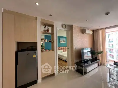 Modern living room with sleek design, featuring a compact kitchen and cozy bedroom view.