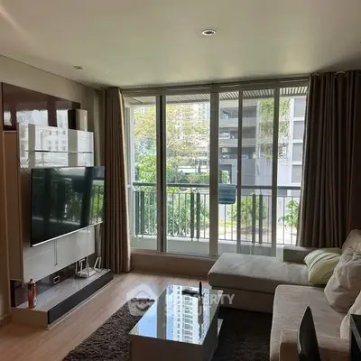 Modern living room with large windows and stylish furniture in a high-rise apartment.