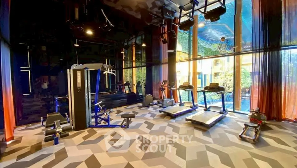 Luxurious gym with modern equipment and vibrant design in upscale residential complex.