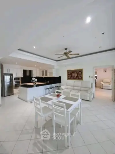 Spacious open-plan living room with modern kitchen and elegant dining area.