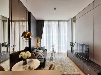 Modern living room with elegant decor and large windows, featuring a cozy seating area and stylish lighting.