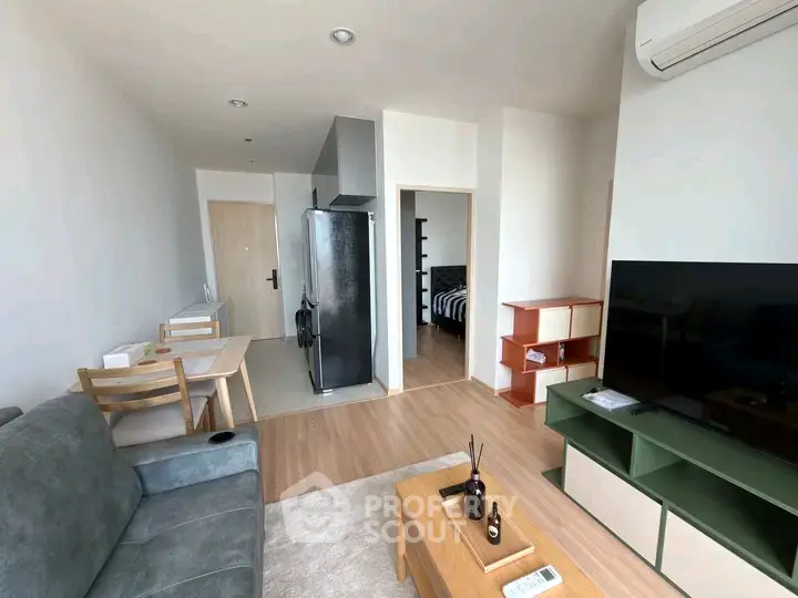 Modern living room with sleek furniture and open layout, featuring a cozy dining area and stylish decor.