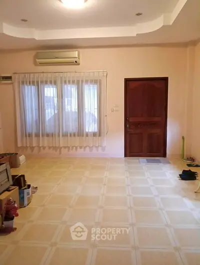 Spacious living room with tiled floor and large window, perfect for cozy gatherings.