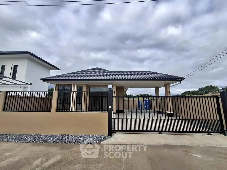 Modern single-story house with gated driveway and sleek exterior design.