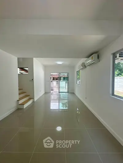 Spacious modern living room with glossy tiled floors and natural light