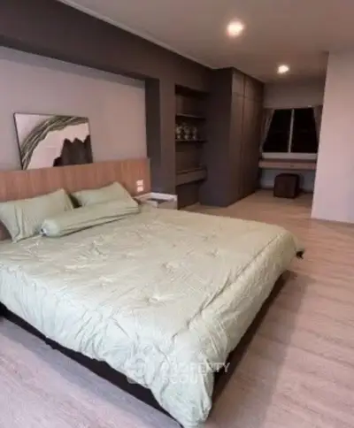 Spacious modern bedroom with stylish decor and ample natural light.