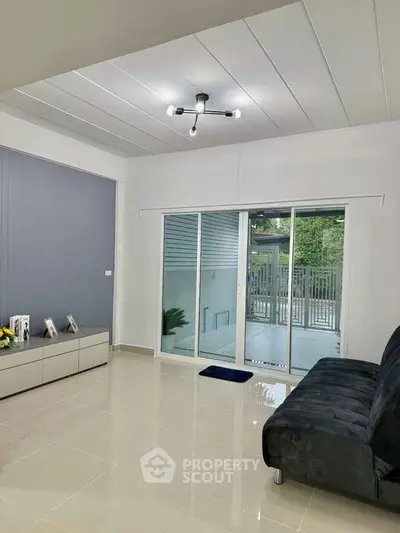 Modern living room with sleek design and sliding glass doors to patio.
