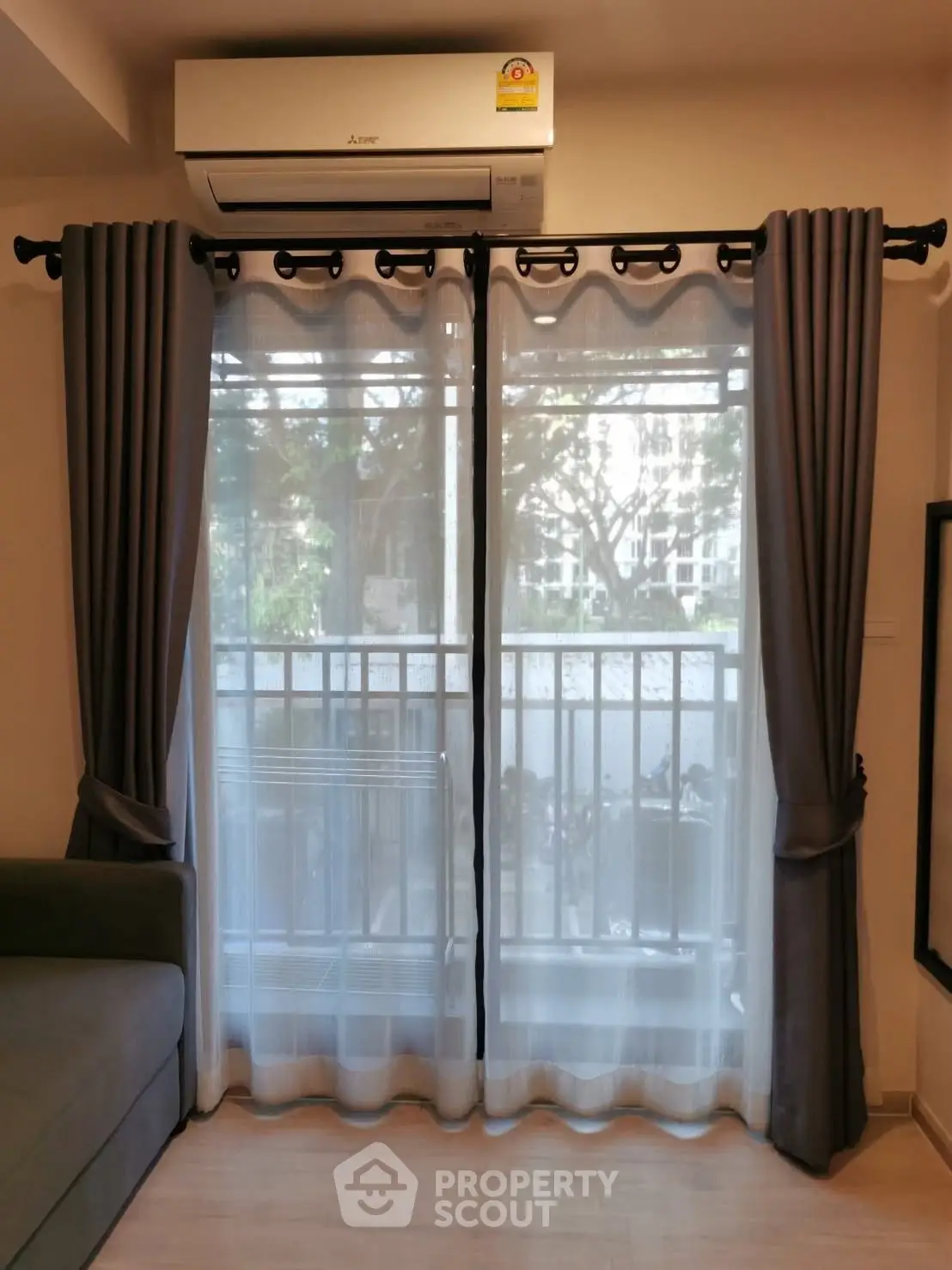 Cozy living room with balcony view and modern air conditioning unit