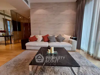 Luxurious living room with elegant sofa and marble coffee table, featuring floor-to-ceiling windows.