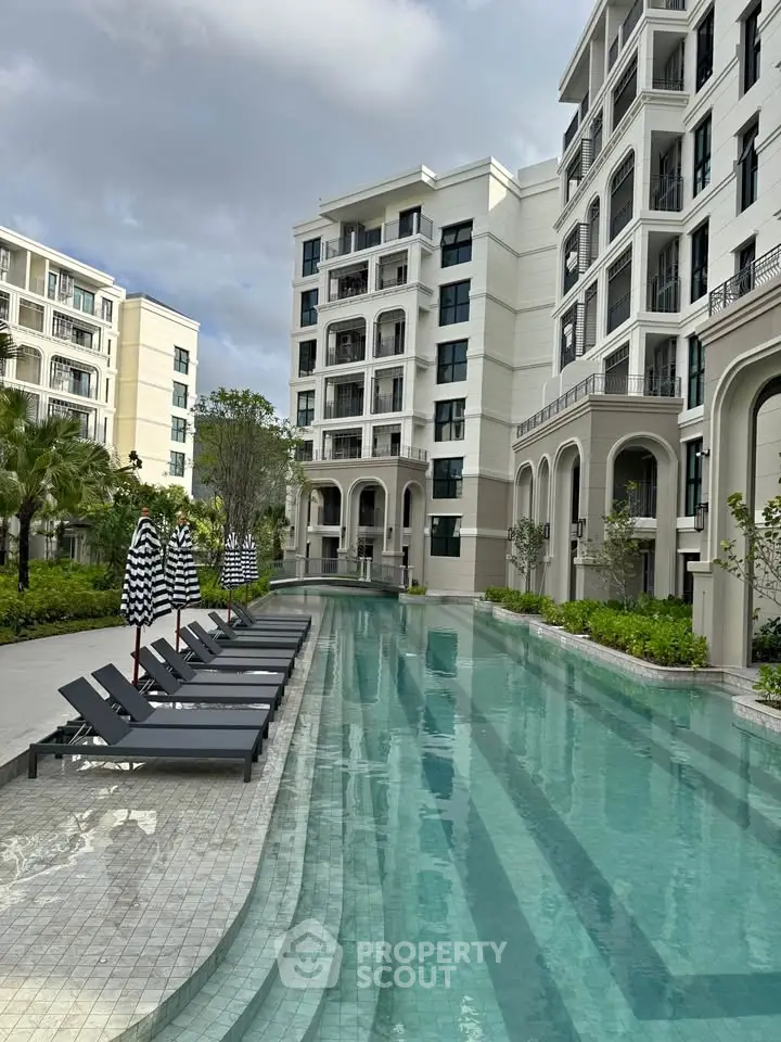 Luxurious apartment complex with elegant poolside and modern architecture.