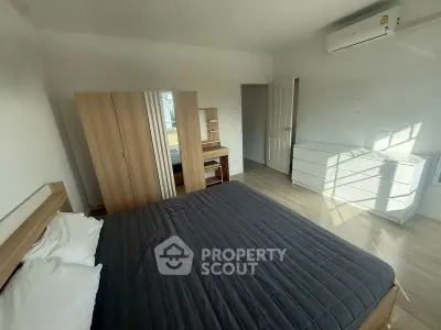 Spacious bedroom with modern furniture and air conditioning in a bright apartment.