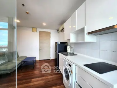 Modern kitchen with sleek white cabinets, washing machine, and glass partition in stylish apartment.