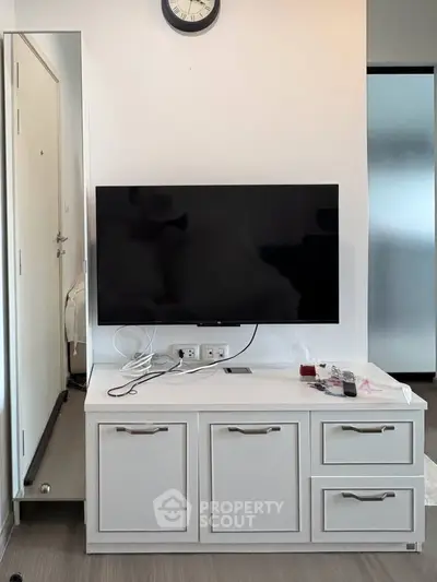 Modern living room with wall-mounted TV and sleek storage unit