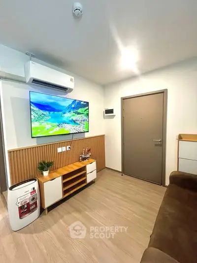 Modern living room with wall-mounted TV and air conditioning in stylish apartment.