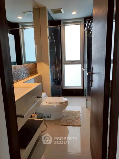 Modern bathroom with sleek fixtures and large windows in a contemporary apartment.