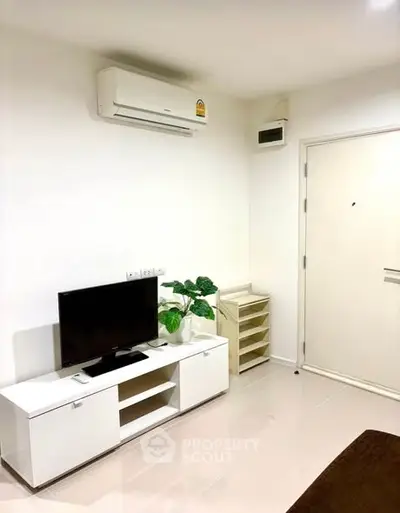 Modern living room with sleek white furniture and air conditioning unit.