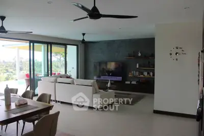 Spacious modern living room with large windows and scenic view, featuring elegant decor and comfortable seating.