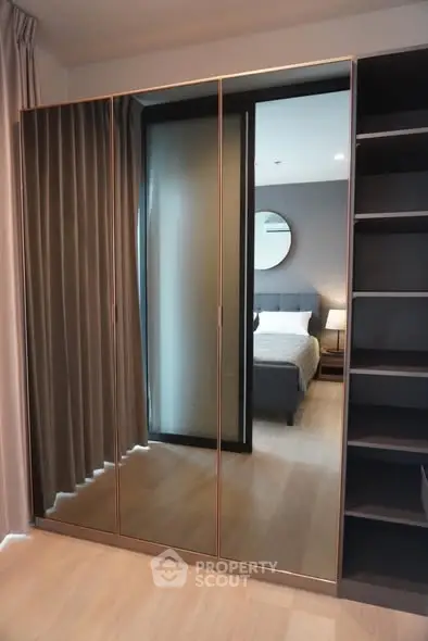 Stylish bedroom with mirrored wardrobe and modern decor
