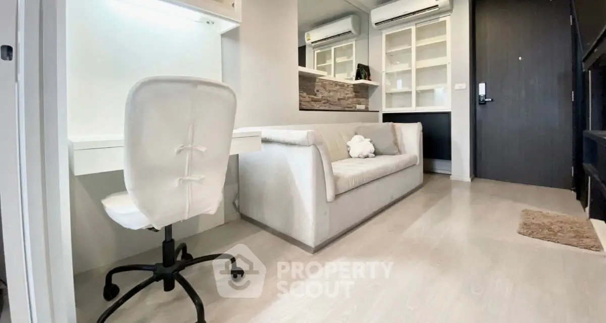 Modern living room with sleek design, featuring a cozy sofa and a stylish study area.