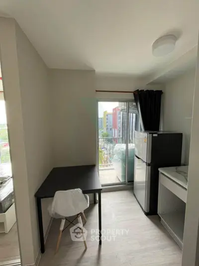 Modern apartment with compact kitchen and balcony view, ideal for urban living.