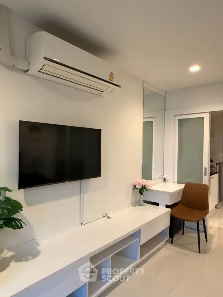 Modern living room with wall-mounted TV and sleek air conditioning unit.