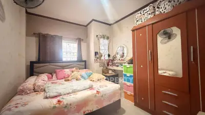 Cozy bedroom with floral bedding and ample storage in a charming home.