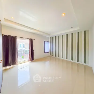 Spacious empty room with large windows and modern striped accent wall, perfect for customization.