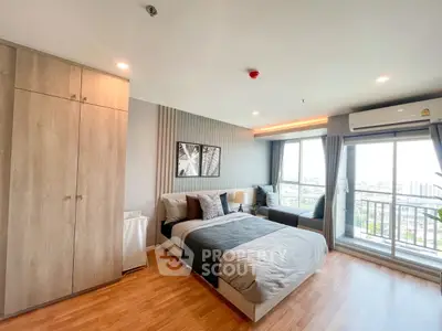 Spacious modern bedroom with large windows and city view, featuring stylish decor and ample natural light.