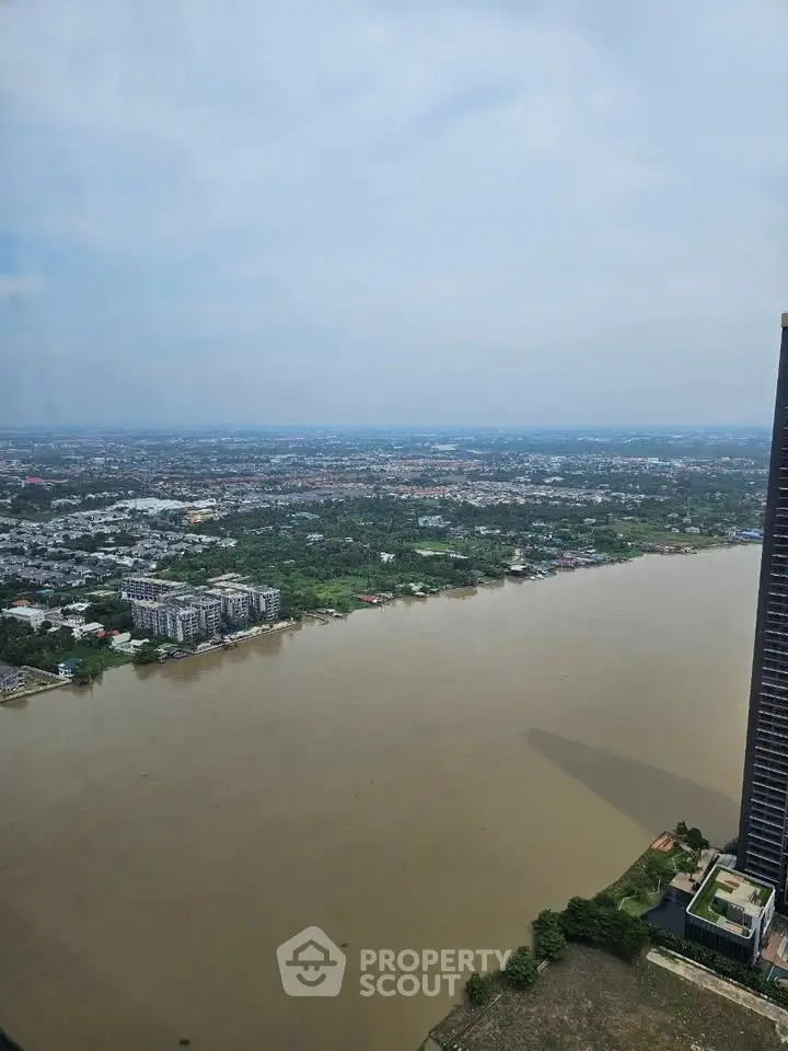 Stunning river view from high-rise building showcasing expansive cityscape and lush greenery.