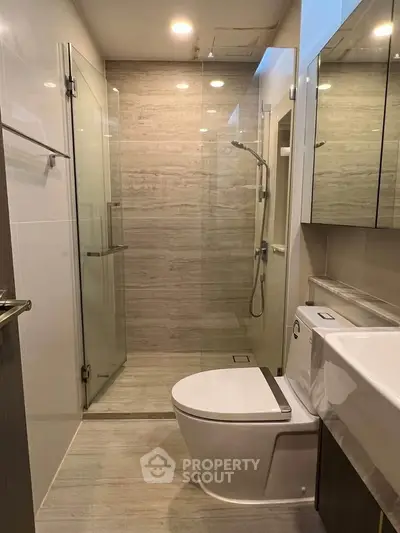 Modern bathroom with glass shower and sleek fixtures in a contemporary apartment.