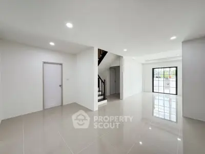Spacious modern living room with glossy tiled floors and large windows for natural light.