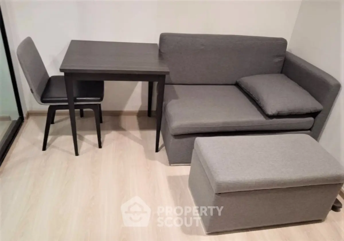 Cozy living room with modern gray sofa and compact dining table, perfect for small spaces.