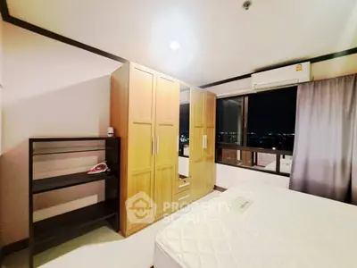 Spacious bedroom with city view, featuring a large wardrobe and air conditioning for comfort.