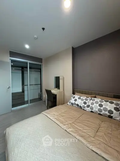 Modern bedroom with stylish decor and cozy bedding in a contemporary apartment.