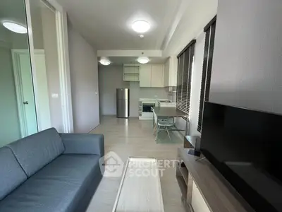 Modern living room with open kitchen layout and sleek furnishings in a contemporary apartment.