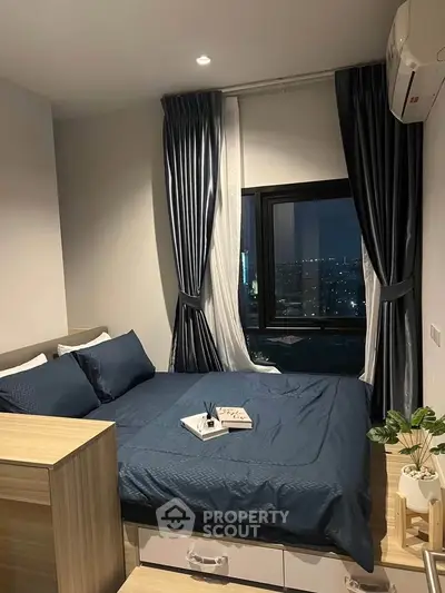 Cozy bedroom with city view, featuring elegant curtains and modern decor, perfect for urban living.