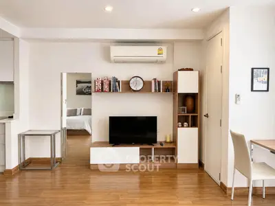 Modern living room with sleek furniture and wall-mounted TV in a stylish apartment.
