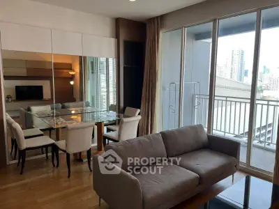Modern living room with city view, featuring a cozy sofa and elegant dining area.