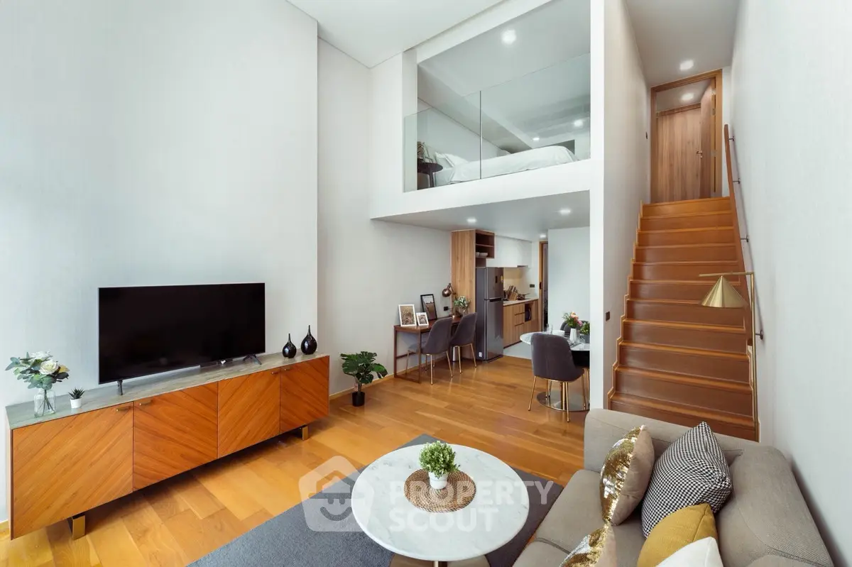 Modern loft-style living room with high ceilings, wooden floors, and stylish decor in a contemporary apartment.