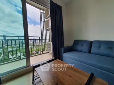 Modern living room with blue sofa and balcony view of city skyline.