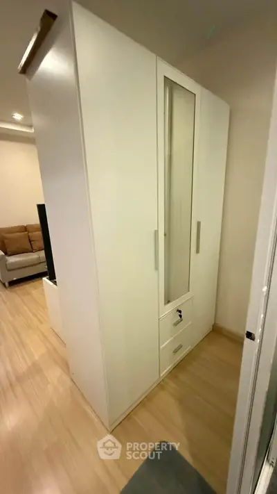 Modern interior with sleek white wardrobe and cozy living room setup.