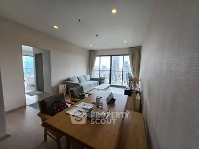 Spacious living room with city view, featuring modern furniture and natural light, ideal for urban living.