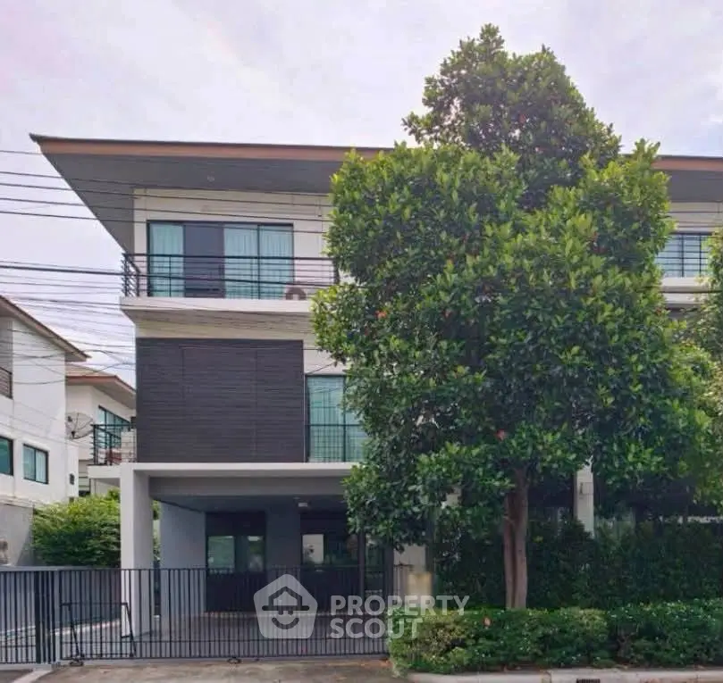 Modern three-story townhouse with sleek design and lush greenery in a serene neighborhood.