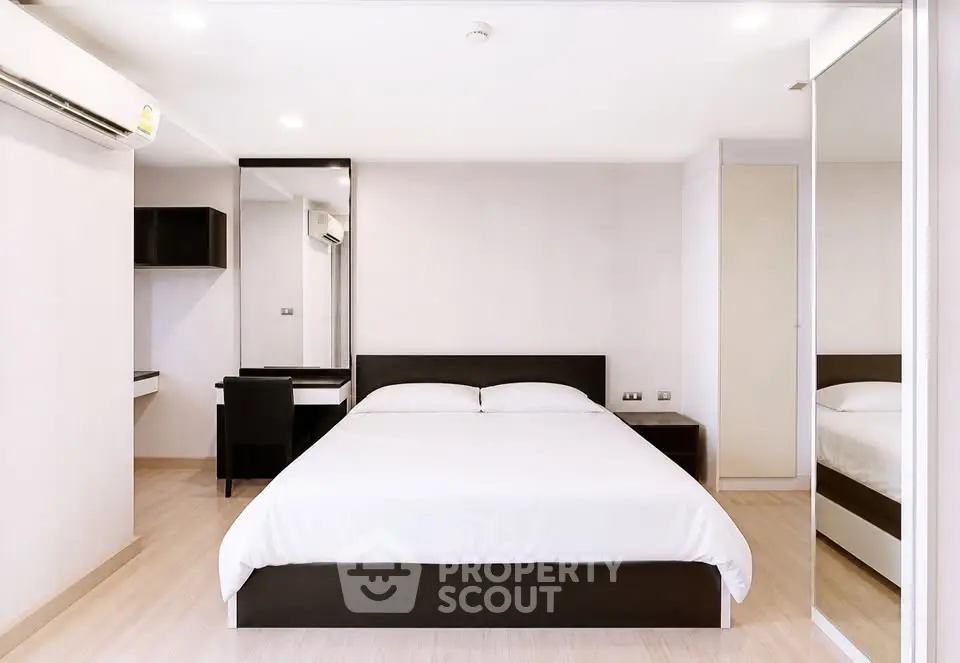 Modern minimalist bedroom with sleek furniture and ample natural light