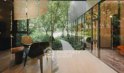 Modern interior with glass walls overlooking lush garden pathway