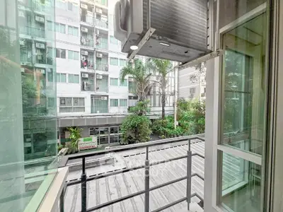 Charming balcony view overlooking lush greenery and modern building facade, perfect for urban living.