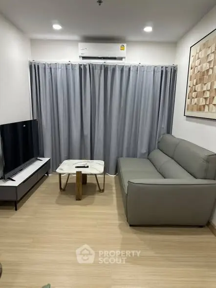 Modern living room with sleek furniture and stylish decor, featuring a comfortable sofa and flat-screen TV.