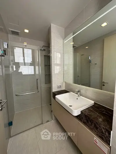 Modern bathroom with glass shower and elegant vanity in luxury apartment