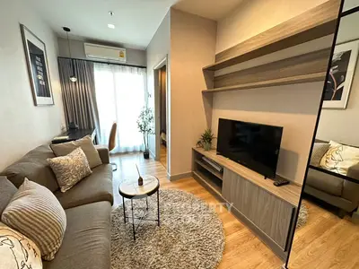 Modern living room with cozy sofa, stylish decor, and natural light from large window.